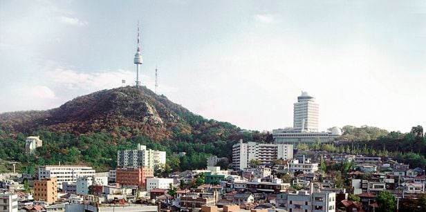 1983년 촬영된 남산 일대. 사진 오른쪽 위로 솟아오른 건물은 1970년 5월 준공된 지상 18층 규모 옛 남산 어린이회관과 천체투영관(현재는 서울시교육청 교육연구정보원 건물). 이 건물 왼쪽 아래 ‘ㄷ’자 모양 아파트가 회현아파트다. 남산타워 아래쪽에 있는 아파트는 1975년 준공된 삼풍맨션아파트. /서울역사아카이브